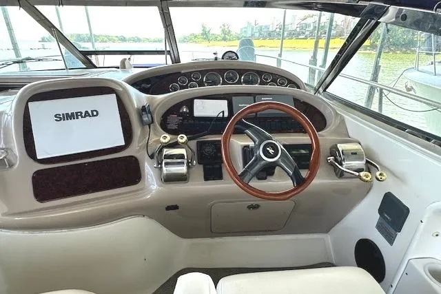 Slide: The Image of 2001 Sea Ray 380 Sundancer helm with Simrad navigation system and wood-accented steering wheel. - 10