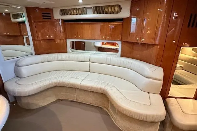 Slide: The Image of Luxurious interior of a 2001 Sea Ray 380 Sundancer with plush seating and wooden cabinetry. - 16