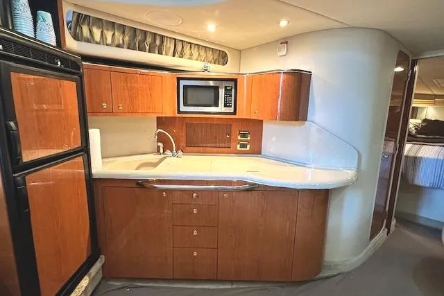 Slide: The Image of Luxurious 2001 Sea Ray 380 Sundancer yacht kitchen with wood cabinetry and modern appliances. - 17