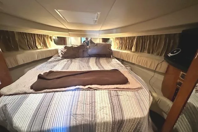 Slide: The Image of Interior cabin of 2001 Sea Ray 380 Sundancer with cozy bed and striped bedding. - 19