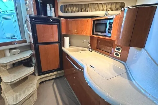 Slide: The Image of 2001 Sea Ray 380 Sundancer yacht kitchen with wood cabinetry and modern appliances. - 22
