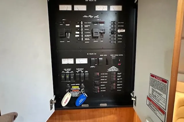 Slide: The Image of Electrical panel of a 2001 Sea Ray 380 Sundancer boat with labeled switches and keys. - 24