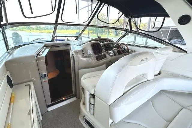 Slide: The Image of 2001 Sea Ray 380 Sundancer cockpit with white seating and helm, overlooking serene waters. - 28