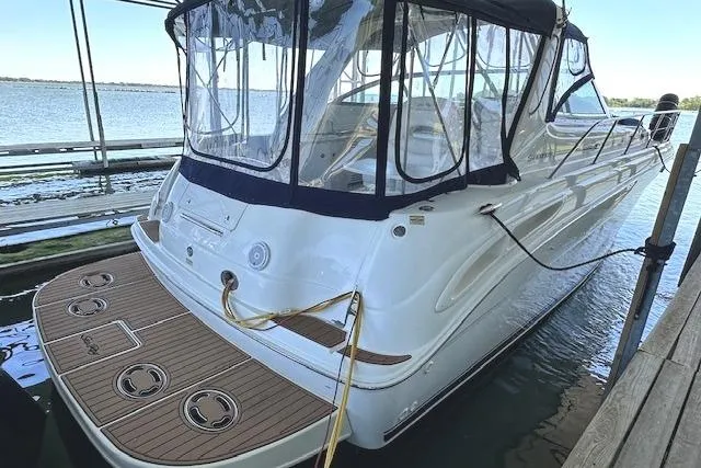 Slide: The Image of 2001 Sea Ray 380 Sundancer yacht docked, featuring sleek design and spacious deck. - 3
