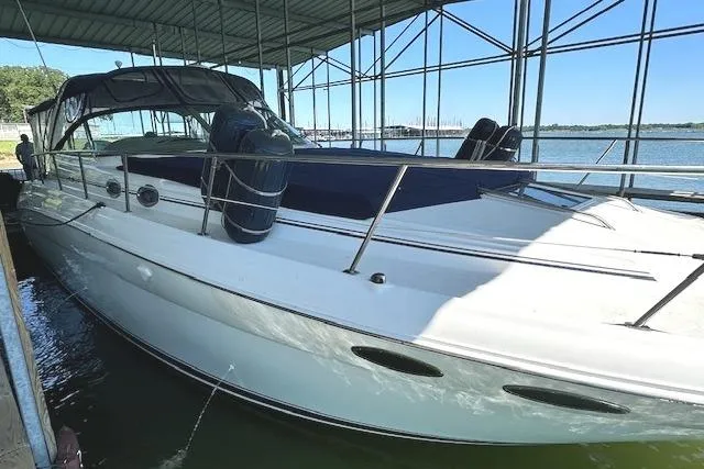 Slide: The Image of 2001 Sea Ray 380 Sundancer docked under a covered marina with scenic water view. - 4