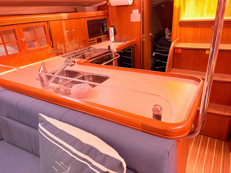 Slide: The Image of Interior of a 2006 Hunter 38 yacht with kitchen and seating area. - 11