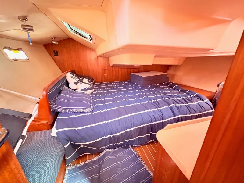 Slide: The Image of Interior of a 2006 Hunter 38 yacht featuring a cozy bedroom. - 15