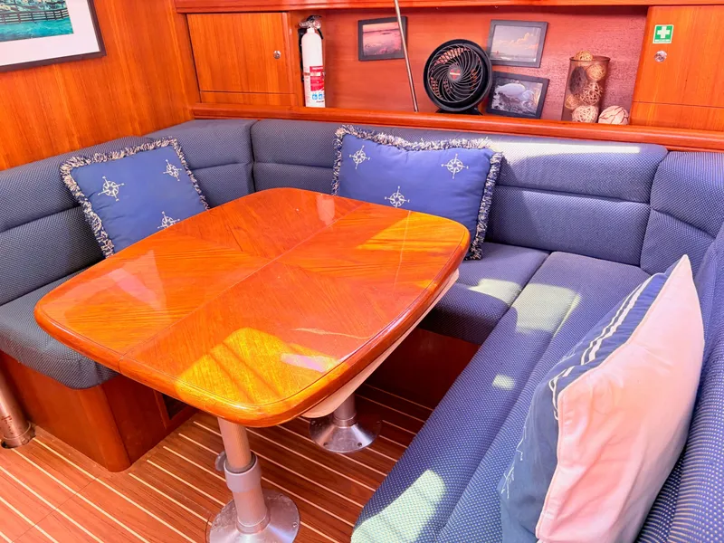 Slide: The Image of Interior of a 2006 Hunter 38 yacht with wooden table and blue cushions. - 17