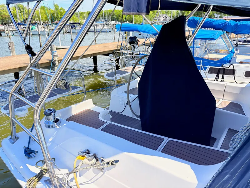 Slide: The Image of 2006 Hunter 38 sailboat docked, featuring covered helm and stainless steel fittings. - 2
