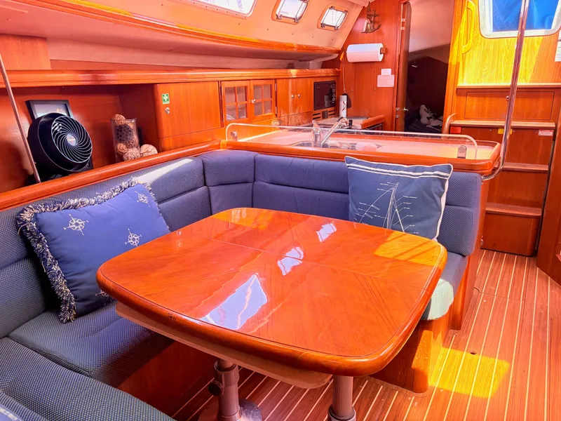 Slide: The Image of Interior of a 2006 Hunter 38 yacht with wooden table and blue cushions. - 23