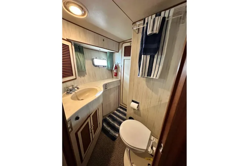 Slide: The Image of Bathroom interior of 1987 Hi-Star 48 Yachtfish, featuring sink, toilet, and nautical decor. - 2