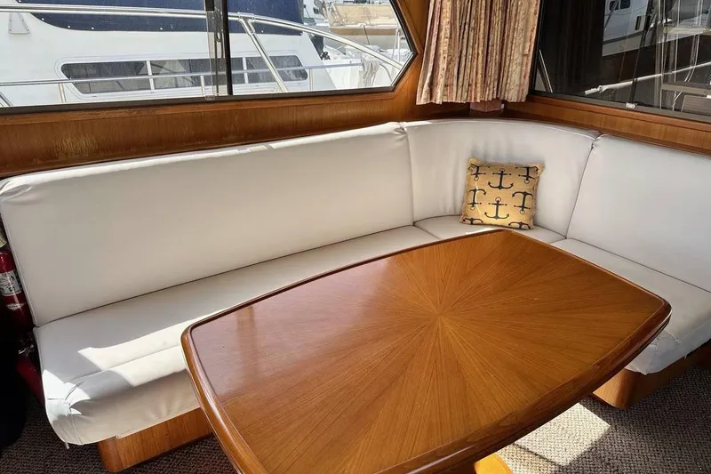 Slide: The Image of Interior of 1987 Hi-Star 48 Yachtfish with white seating and wooden table. - 3