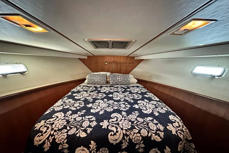 Slide: The Image of Luxurious cabin interior of 1987 Hi-Star 48 Yachtfish with elegant bedding and wood paneling. - 6