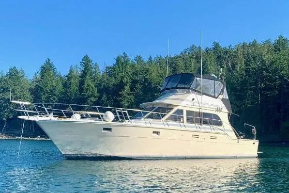 Slide: The Image of 1987 Hi-Star 48 Yachtfish on serene water with forested background. - 7