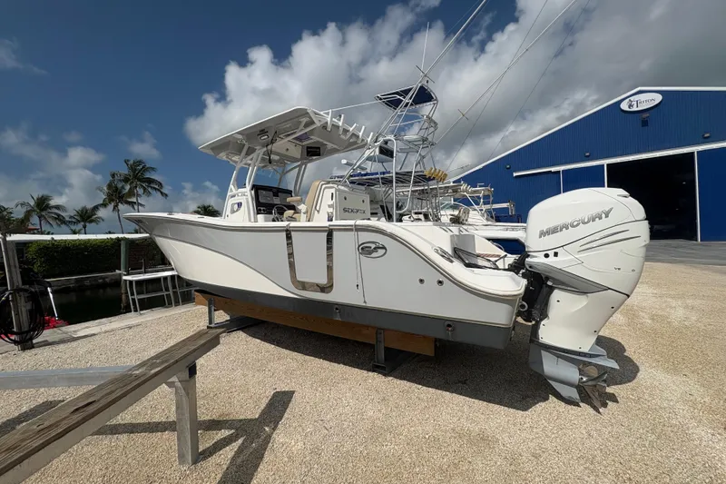 The Image of 2017 Sea Fox 288 Commander boat with Mercury engine, docked near a blue warehouse. - 1