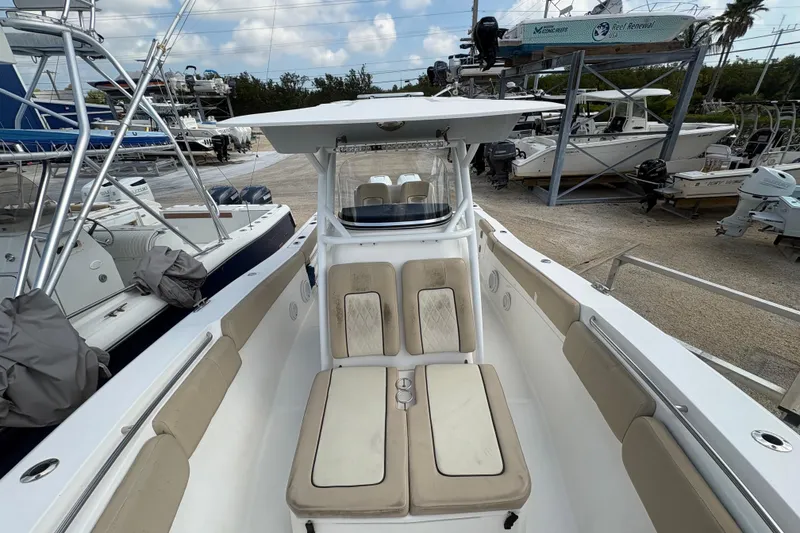 Slide: The Image of 2017 Sea Fox 288 Commander boat with beige seating, docked among other vessels. - 12