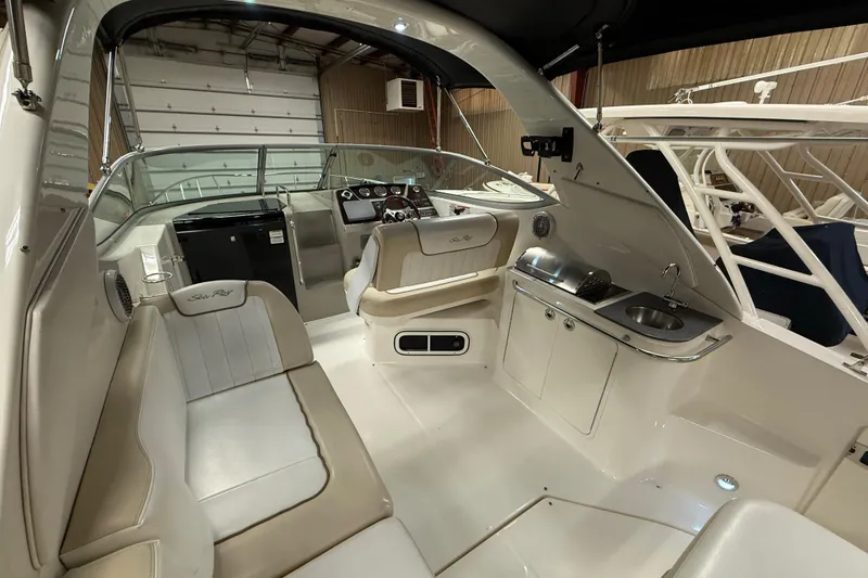 Slide: The Image of 2012 Sea Ray Sundancer 280 interior with seating, helm, and kitchenette area. - 15