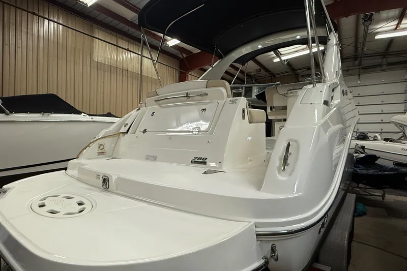 Slide: The Image of 2012 Sea Ray Sundancer 280 yacht in indoor storage, showcasing sleek design and spacious deck. - 2