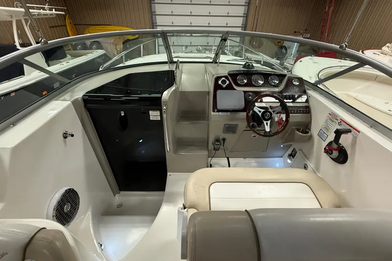 Slide: The Image of 2012 Sea Ray Sundancer 280 cockpit with steering wheel and control panel. - 23