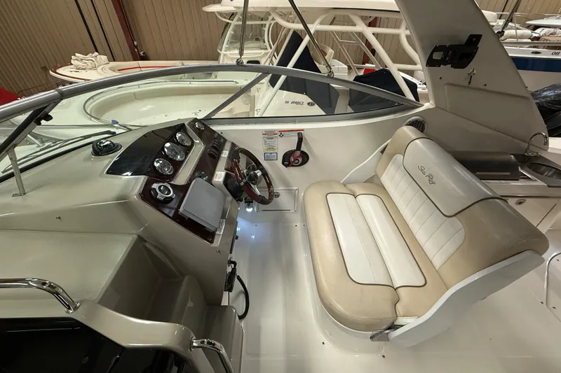 Slide: The Image of 2012 Sea Ray Sundancer 280 cockpit with steering wheel and beige seating. - 26