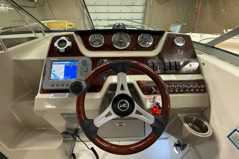 Slide: The Image of Cockpit of 2012 Sea Ray Sundancer 280 with steering wheel and navigation controls. - 29