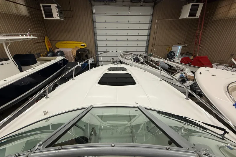 Slide: The Image of 2012 Sea Ray Sundancer 280 in storage, surrounded by other boats in a garage. - 35