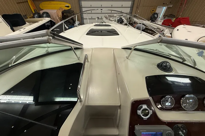 Slide: The Image of 2012 Sea Ray Sundancer 280 cockpit view with dashboard and windshield in a storage facility. - 36
