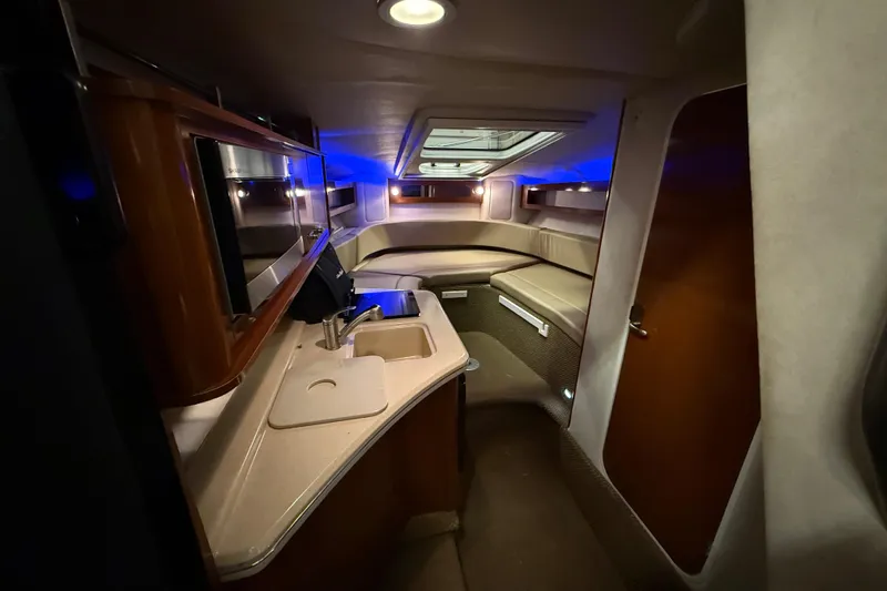 Slide: The Image of Interior of 2012 Sea Ray Sundancer 280, featuring kitchenette and cozy seating area. - 44