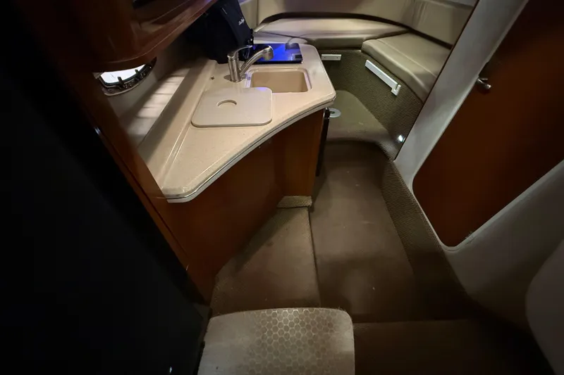 Slide: The Image of Interior of 2012 Sea Ray Sundancer 280, featuring compact kitchenette and seating area. - 45