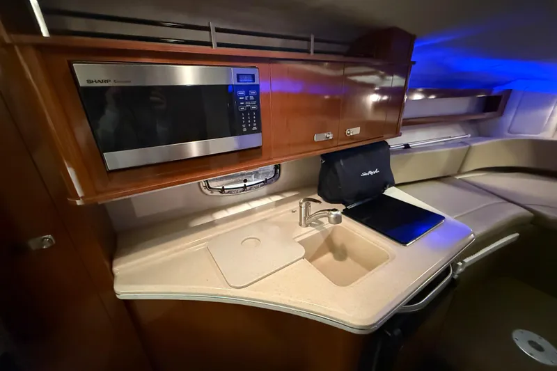 Slide: The Image of 2012 Sea Ray Sundancer 280 cabin kitchen with microwave, sink, and countertop. - 46