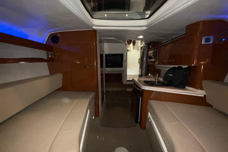 Slide: The Image of Interior of 2012 Sea Ray Sundancer 280, featuring seating, kitchenette, and modern amenities. - 56