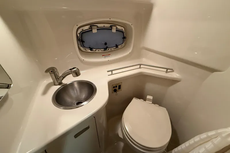 Slide: The Image of 2012 Sea Ray Sundancer 280 bathroom with sink, toilet, and porthole window. - 68