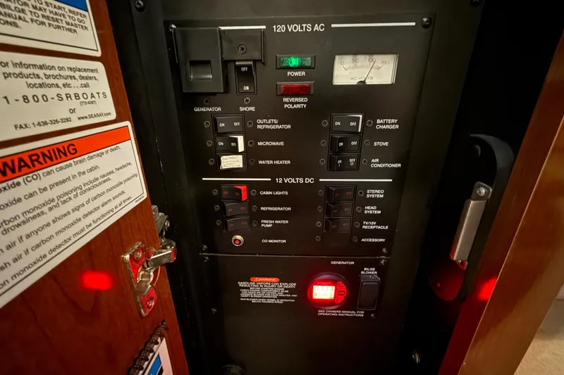 Slide: The Image of Electrical control panel on a 2012 Sea Ray Sundancer 280 boat, featuring various switches and warnings. - 70