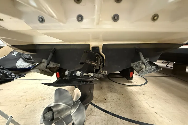 Slide: The Image of 2012 Sea Ray Sundancer 280 boat stern with propeller and trim tabs in a garage. - 78