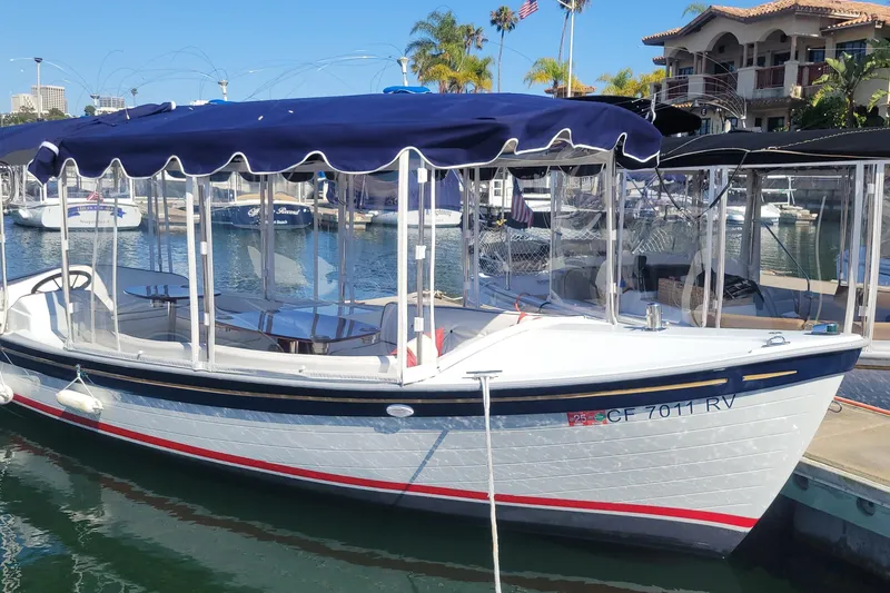 Slide: The Image of 2013 Duffy 21 boat docked in marina with blue canopy and clear side panels. - 14