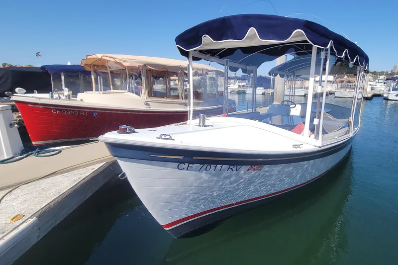 Slide: The Image of 2013 Duffy 21 boat docked in marina, featuring blue canopy and white hull. - 6