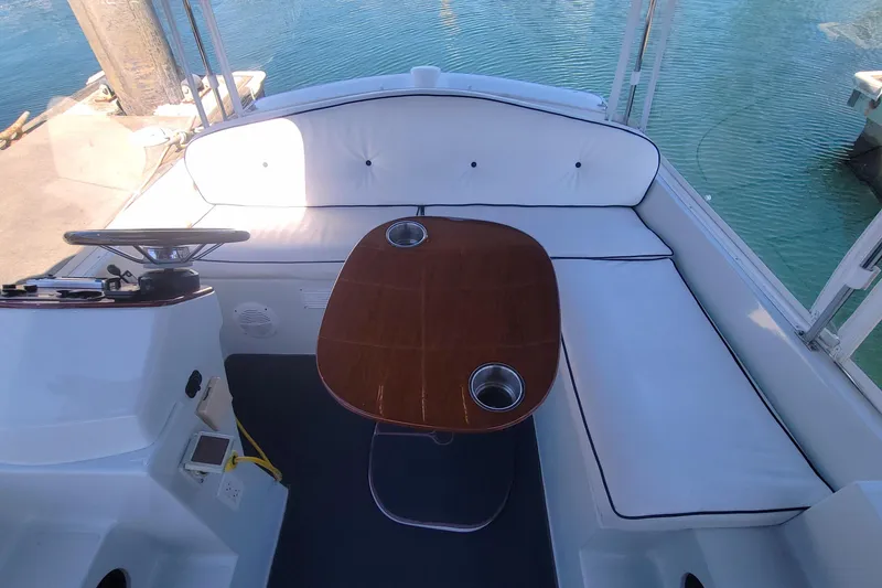 Slide: The Image of Interior of 2013 Duffy 21 boat with white seating and wooden table. - 8