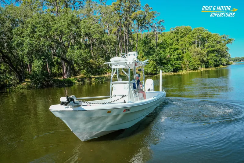 Slide: The Image of 2023 Andros 26 Tarpon boat cruising on a scenic river with lush greenery. - 14