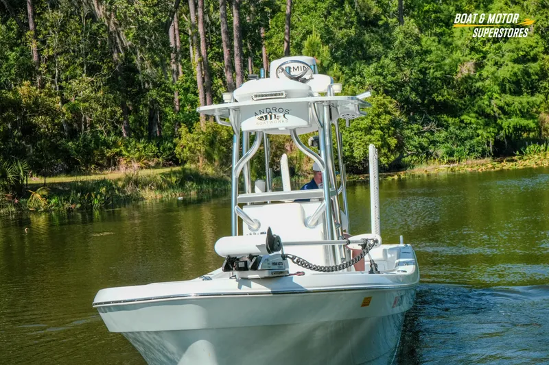 Slide: The Image of 2023 Andros 26 Tarpon boat navigating a serene, tree-lined waterway. - 16