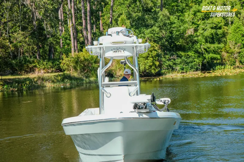 Slide: The Image of 2023 Andros 26 Tarpon boat navigating a serene, tree-lined waterway. - 17