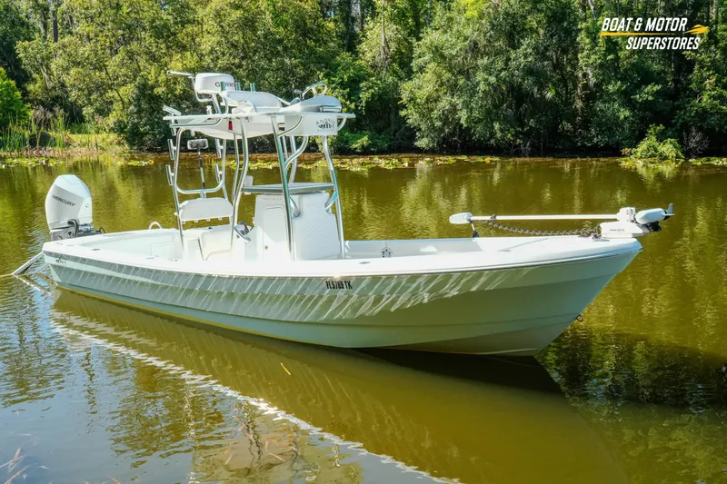 Slide: The Image of 2023 Andros 26 Tarpon boat on a calm lake with lush greenery. - 21