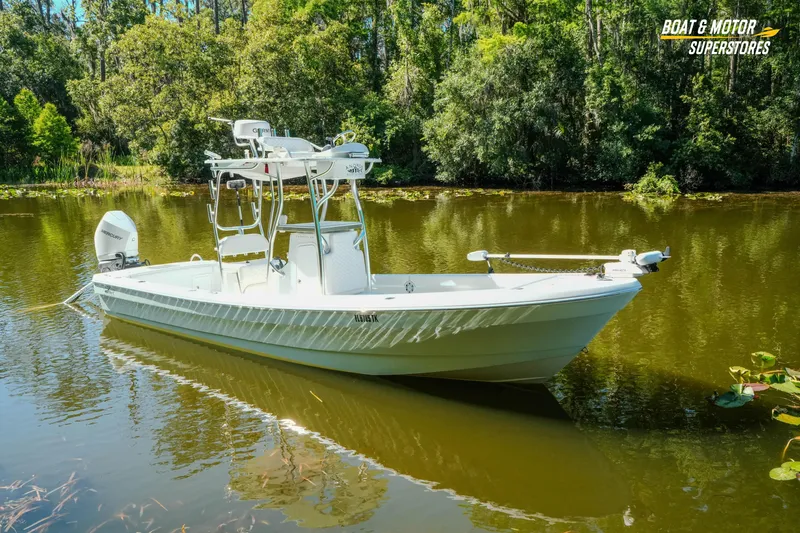 Slide: The Image of 2023 Andros 26 Tarpon boat on a serene lake surrounded by lush greenery. - 22