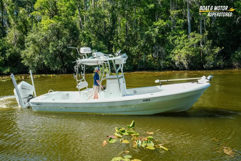 Slide: The Image of 2023 Andros 26 Tarpon boat cruising on a scenic river with lush greenery. - 23