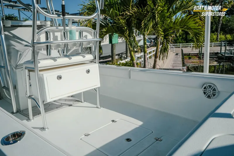Slide: The Image of 2023 Andros 26 Tarpon boat interior with seating and storage, docked near palm trees. - 9