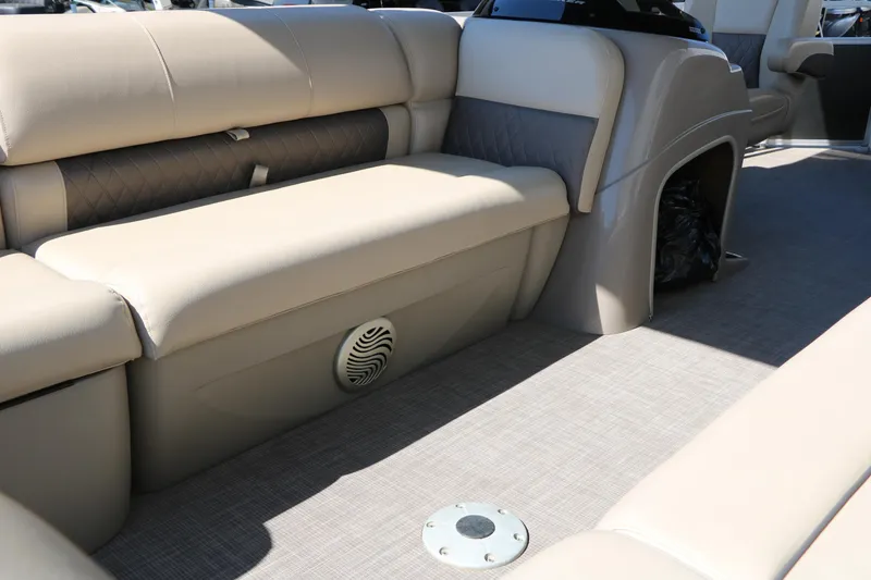 Slide: The Image of 2021 Sun Tracker Party Barge 20 DLX interior with beige seating and speaker. - 19