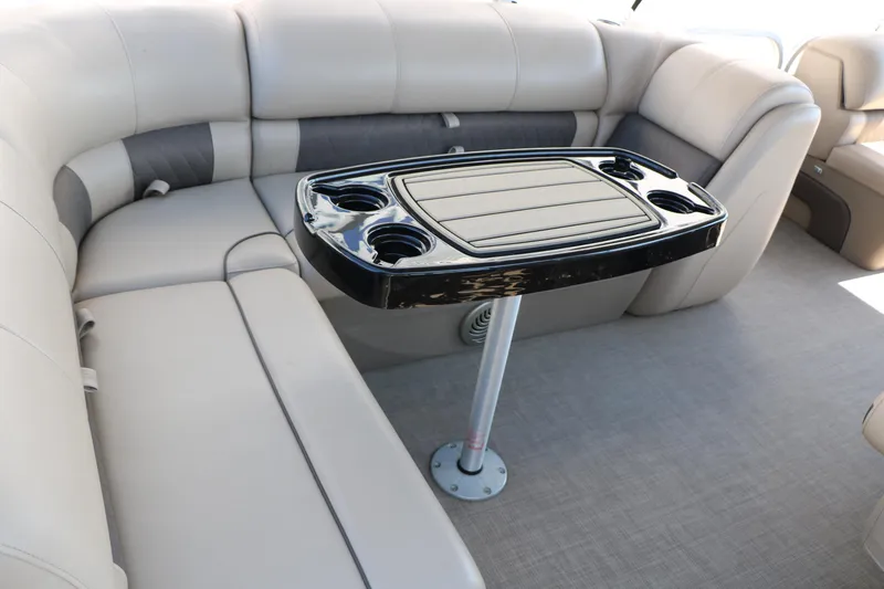 Slide: The Image of 2021 Sun Tracker Party Barge 20 DLX interior with cushioned seating and a central table. - 28