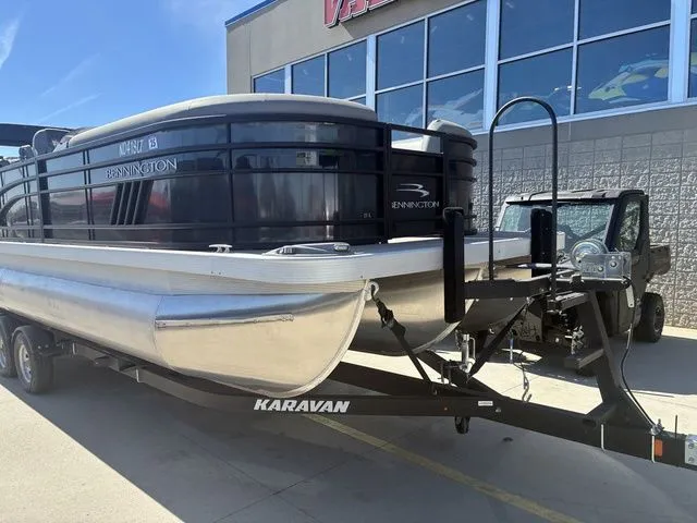 Slide: The Image of 2022 Bennington 23LSR SPS pontoon boat on trailer outside store. - 3