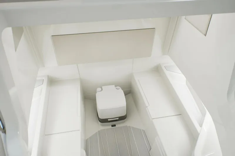 Slide: The Image of Interior cabin of 2026 Wellcraft 28 T-Top boat, featuring seating and compact toilet. - 10