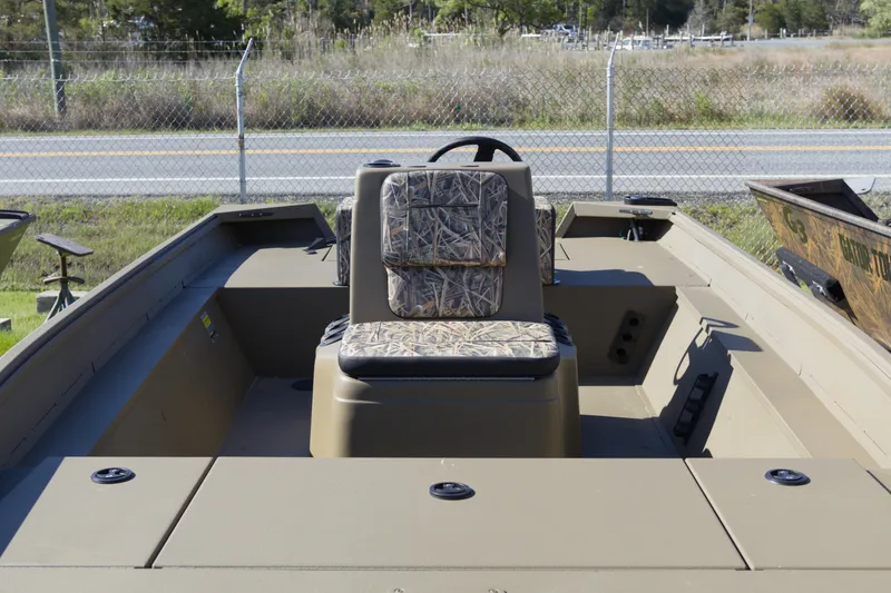 Slide: The Image of 2026 G3 Gator Tough 18 CC boat interior with camouflage seating, parked outdoors. - 3