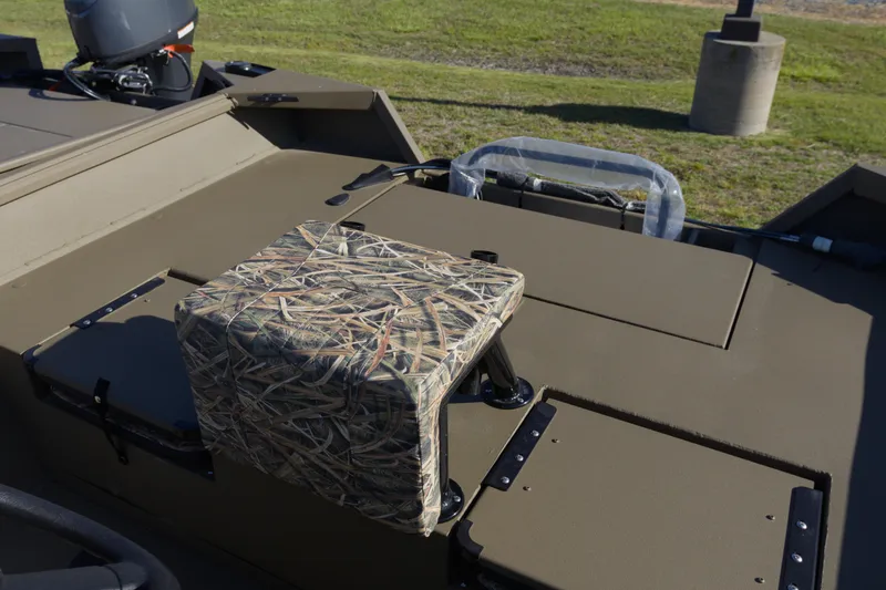 Slide: The Image of 2026 G3 Gator Tough 20 CC boat with camo seat and motor, parked on grass. - 11